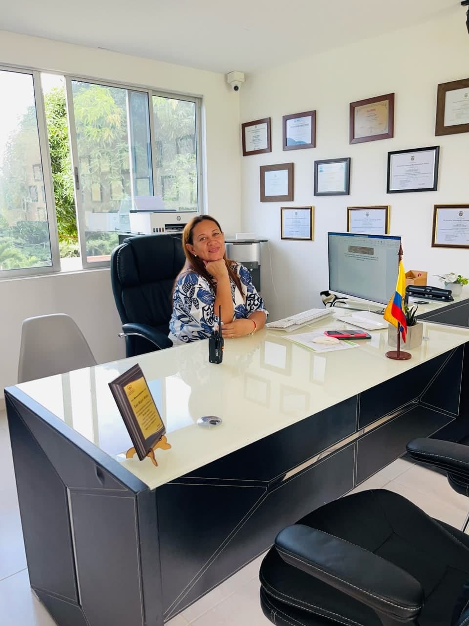Eloisa Pérez Espitia en su escritorio, con sus diplomas en la pared